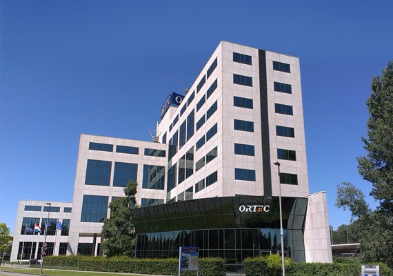 Een foto van het ORTEC gebouw in Zoetermeer. Dit is het hoofdkantoor. Je ziet een strakblauwe lucht.