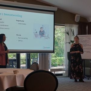 Foto van Esmee en Stephanie die de customer journey presenteren tijdens de Heidag 2022.